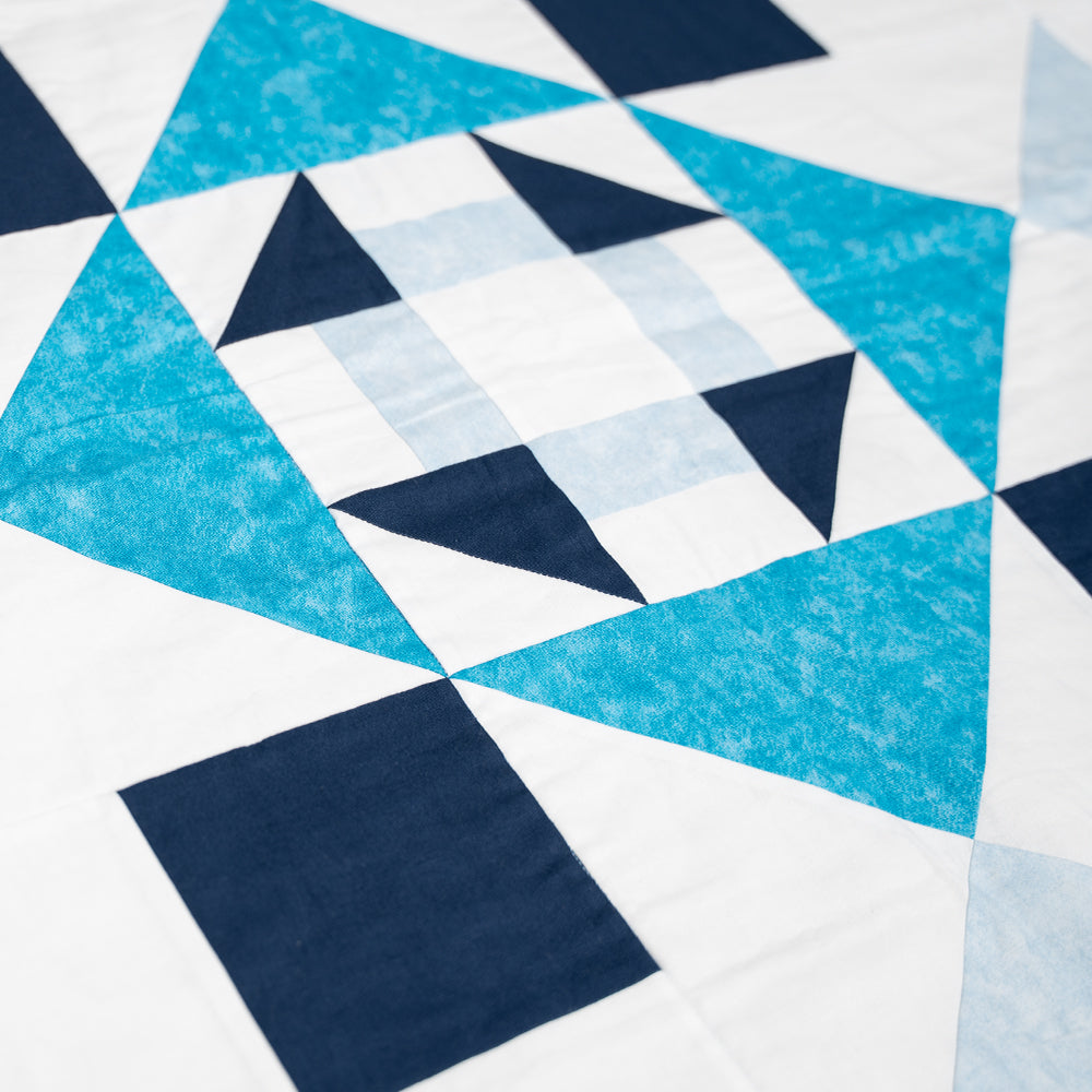 Détails d'une courtepointe blanche et bleue réalisée dans le cadre d'un cours de couture