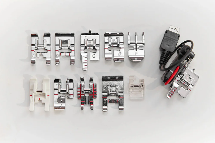 Accessoires pour machine à coudre Husqvarna Viking EPIC™ Quilt 97 – Ensemble de pieds-de-biche et accessoires variés, comprenant plusieurs pieds spécialisés pour différents types de couture et un câble USB.