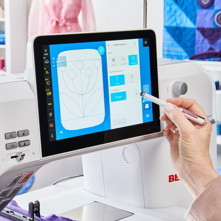 Bernina 990 machine à coudre avec écran tactile et stylet, affichant des réglages précis pour la création de motifs personnalisés.