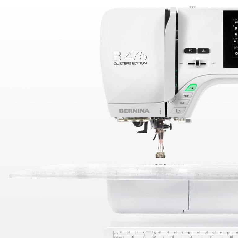 Machine à coudre Bernina 475 QE équipée d'une grande table d'extension transparente, offrant plus d'espace pour les projets de couture.