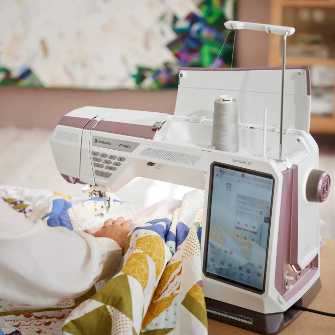 Machine à coudre Husqvarna Viking EPIC™ Quilt 97 en action – Utilisation de la machine pour le quilting avec un large espace de travail, facilitant la couture sur de grandes pièces de tissu.