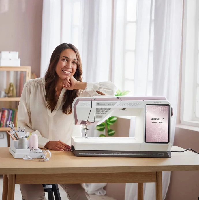 Machine à coudre Husqvarna Viking EPIC™ Quilt 97 en utilisation – Gros plan sur la machine en action, montrant une couturière guidant le tissu sous l'aiguille avec précision.