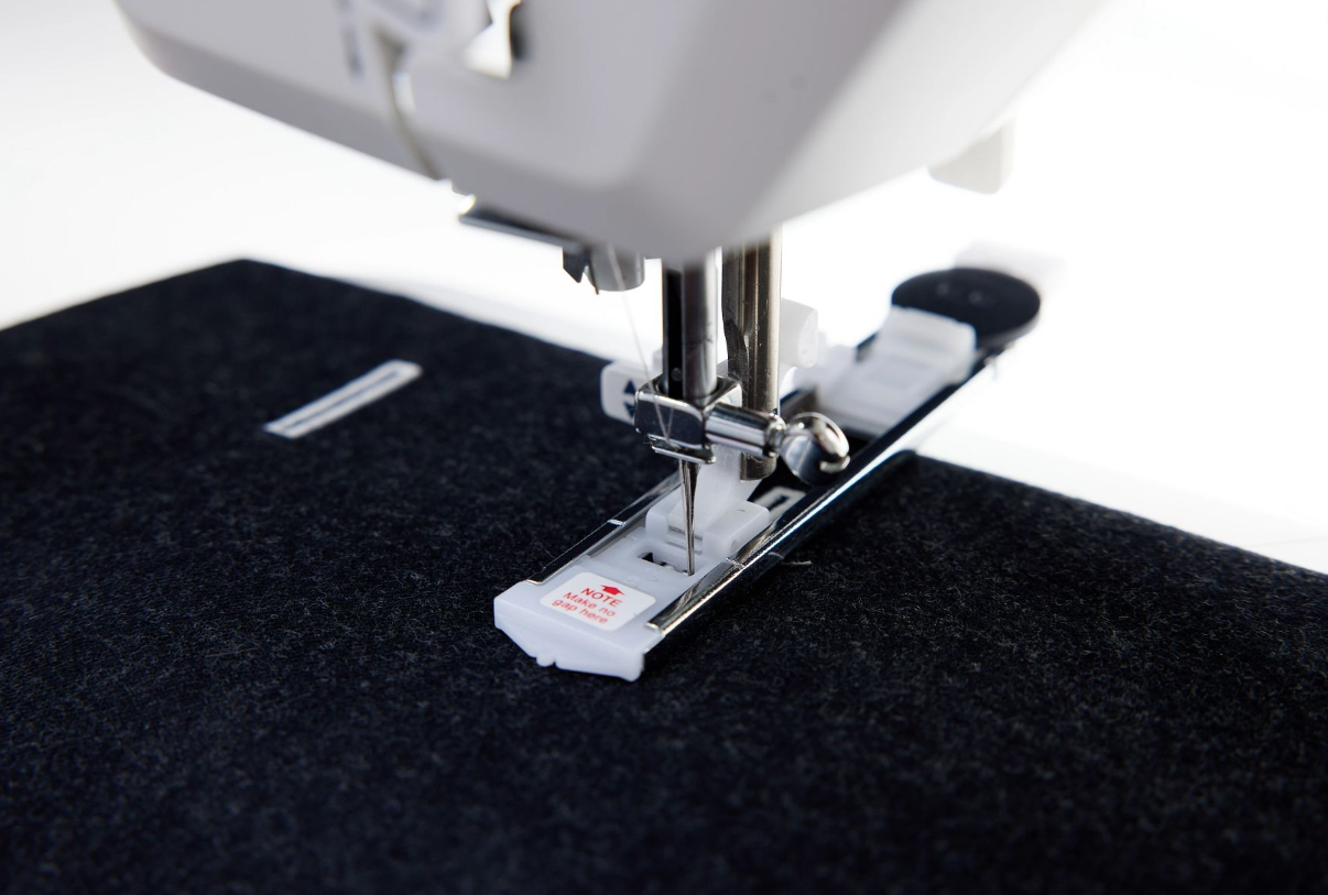 Machine à coudre Husqvarna Viking Onyx 25 – Pied pour boutonnière
Gros plan du pied spécial boutonnière de la machine à coudre Husqvarna Viking Onyx 25, facilitant la couture de boutonnières précises.