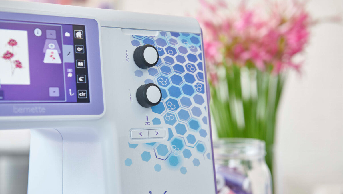 Panneau de contrôle Bernette 79 Yaya Han Edition – Interface tactile et boutons de réglage, avec motifs hexagonaux décoratifs sur la machine.