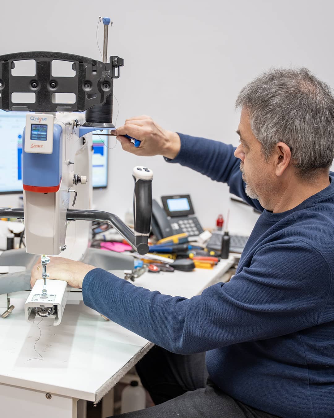 Technicien d’Excelle Machine à Coudre en train de réparer une machine à coudre