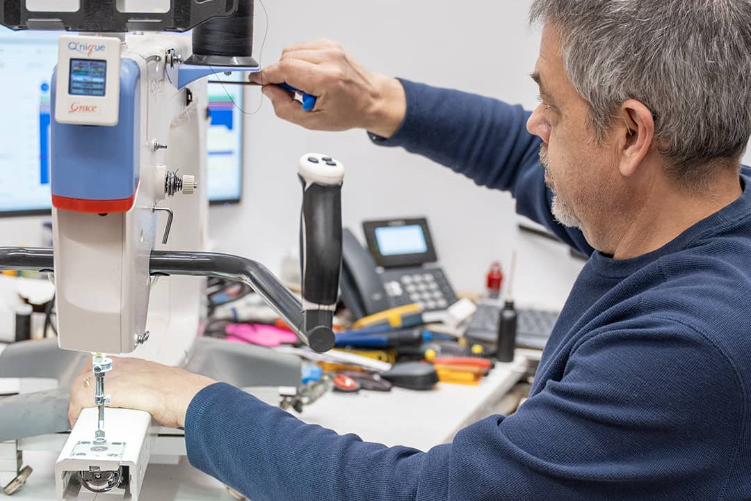 Technicien d’Excelle Machine à Coudre en train de réparer une machine à coudre