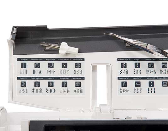 Compartiment intérieur de la Janome M17 avec motifs de points et accessoires.