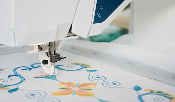 Détail de la broderie réalisée avec la Husqvarna Viking DESIGNER SAPPHIRE™ 85 – Gros plan sur l’aiguille et le motif de broderie coloré, démontrant la précision et la finesse des détails obtenus avec cette machine.