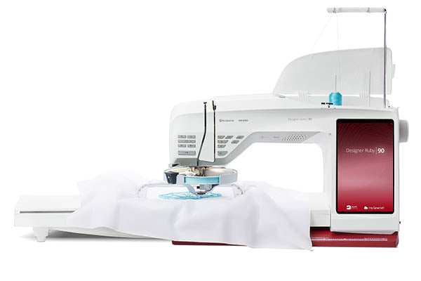 Machine à coudre et à broder Husqvarna Viking DESIGNER RUBY™ 90 – Machine haut de gamme équipée d’un grand écran tactile et d’un module de broderie, idéale pour la couture créative et la personnalisation textile.