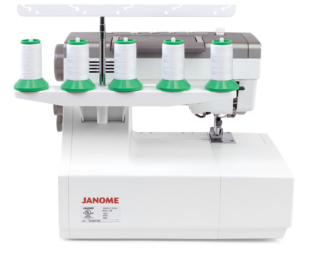 Machine à coudre recouvreuse Janome CoverPro 3000 Professional – Vue arrière de la machine, mettant en avant le porte-bobines pour une utilisation avec plusieurs fils.