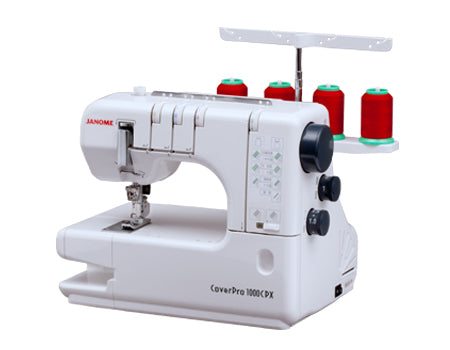 Machine à recouvrement Janome CoverPro 1000CPX, équipée de quatre bobines de fil rouge et d’un bras libre, idéale pour réaliser des coutures extensibles et des ourlets professionnels.