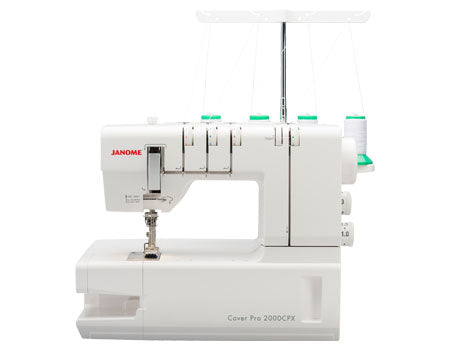 Machine à recouvrement Janome CoverPro 2000CPX, modèle blanc équipé de quatre bobines de fil et d’un bras libre, idéal pour réaliser des ourlets professionnels et des coutures extensibles.