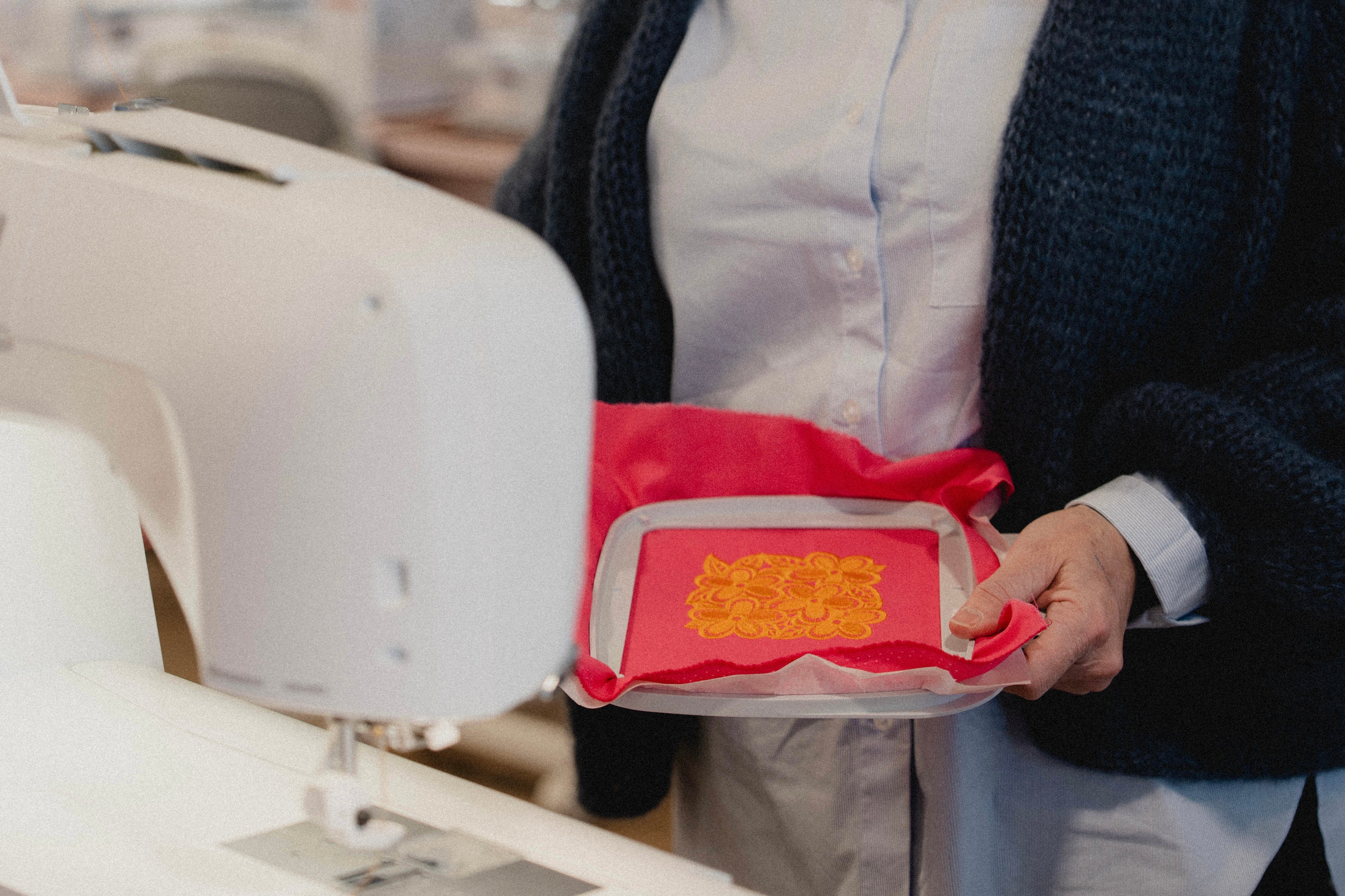 Tissu rose et entoilage placés dans un cerceau de broderie machine