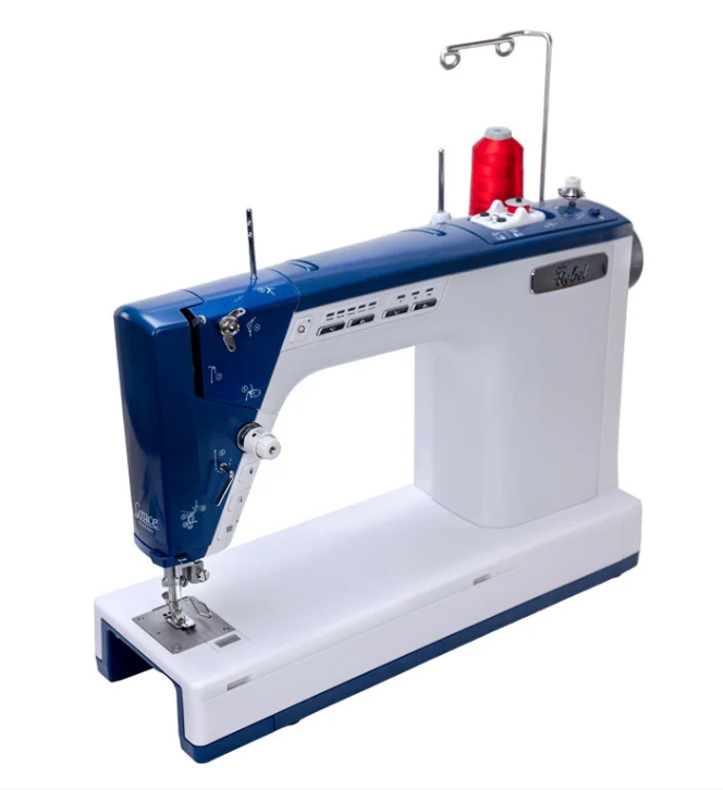 Machine à coudre et à quilter Little Rebel avec un design compact et moderne, équipée d’une bobine de fil rouge et d’un large espace de travail pour des projets de couture et de quilting.