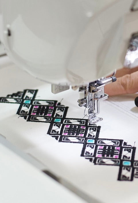 Motifs brodés à la machine, sur un tissus blanc