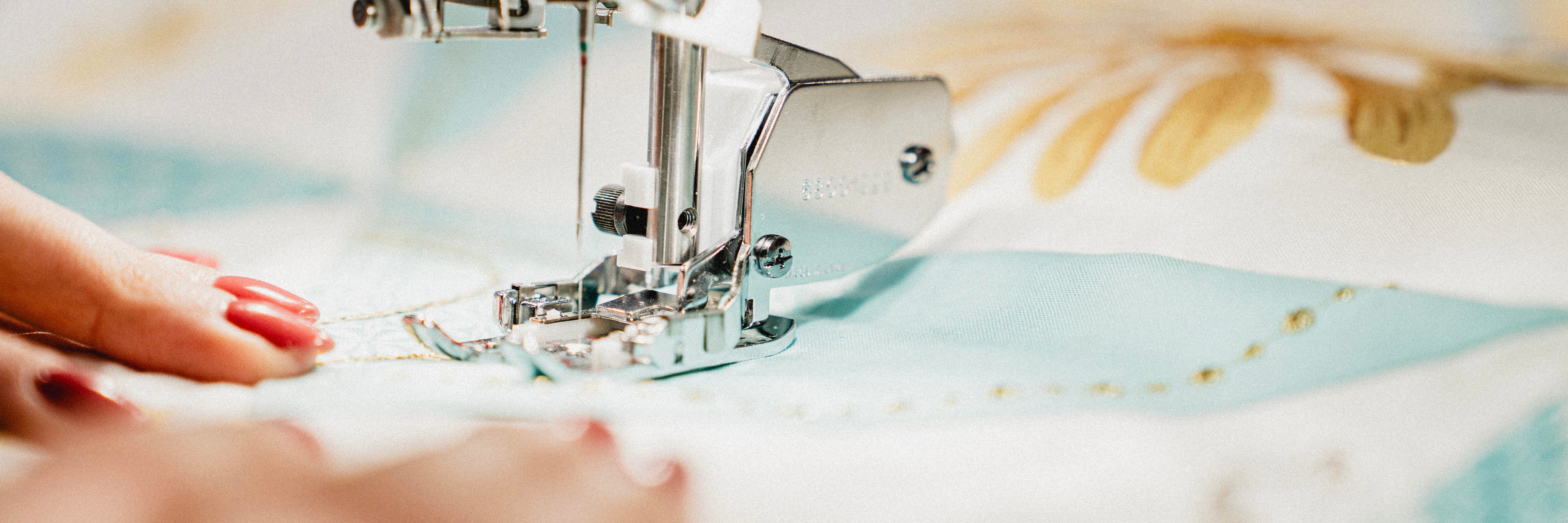 Gros plan sur les mains d'une femme qui s'adonne à la couture à la machine
