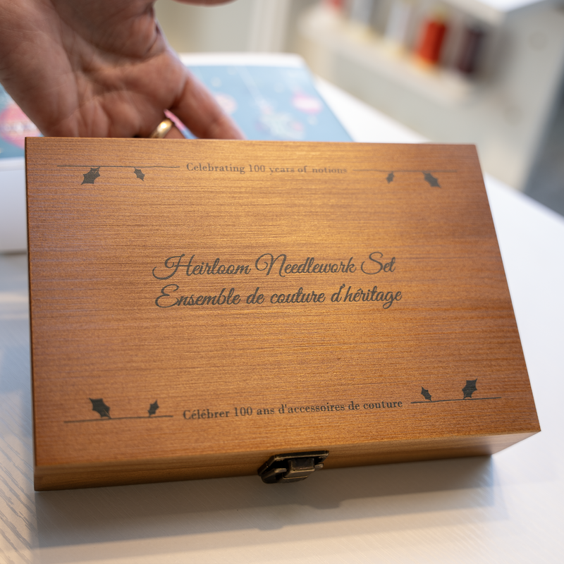 Vue du coffret en bois 'Ensemble de couture d’héritage', avec une inscription célébrant 100 ans d'accessoires de couture.