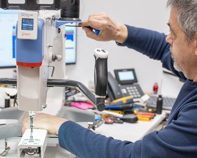 Technicien d’Excelle Machine à Coudre en train de réparer une machine à coudre