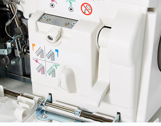 Gros plan du système d'enfilage de la surjeteuse Janome AirThread 2000D – Détail du mécanisme d'enfilage à air, avec des guides colorés facilitant le passage des fils pour une configuration rapide et intuitive.